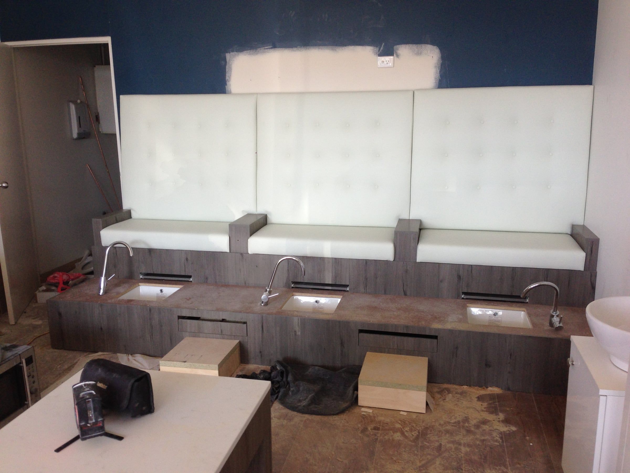 The salon mid-renovation, with new pedicure seating and unfinished floors